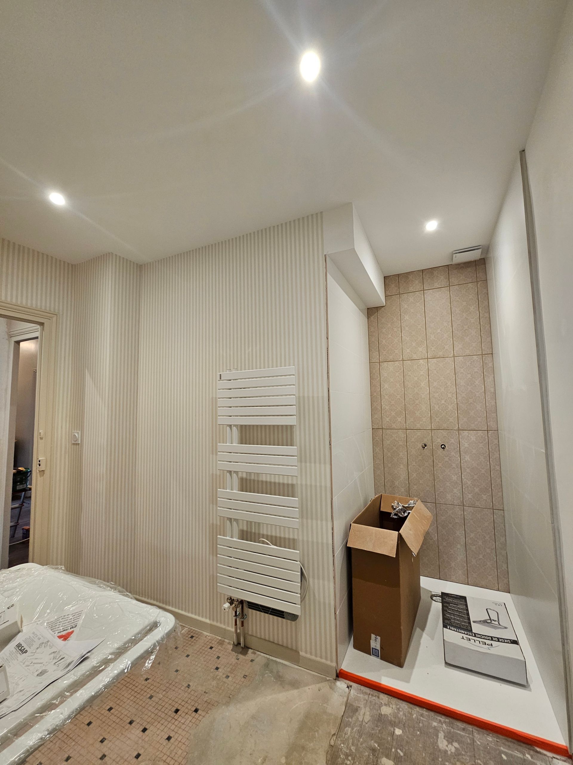 Un sèche serviette accrochée au mur d'une salle de bain