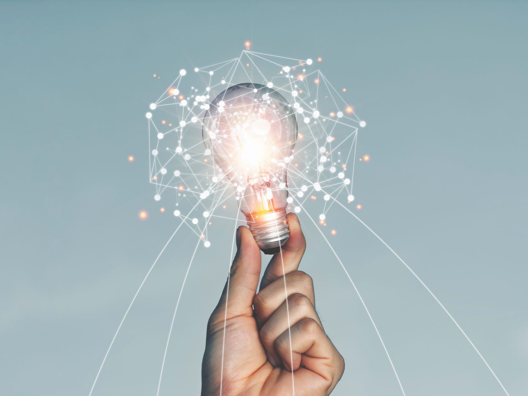 Une main tenant une ampoule allumée reliée à un réseau, symbolisant l'innovation et les idées.
