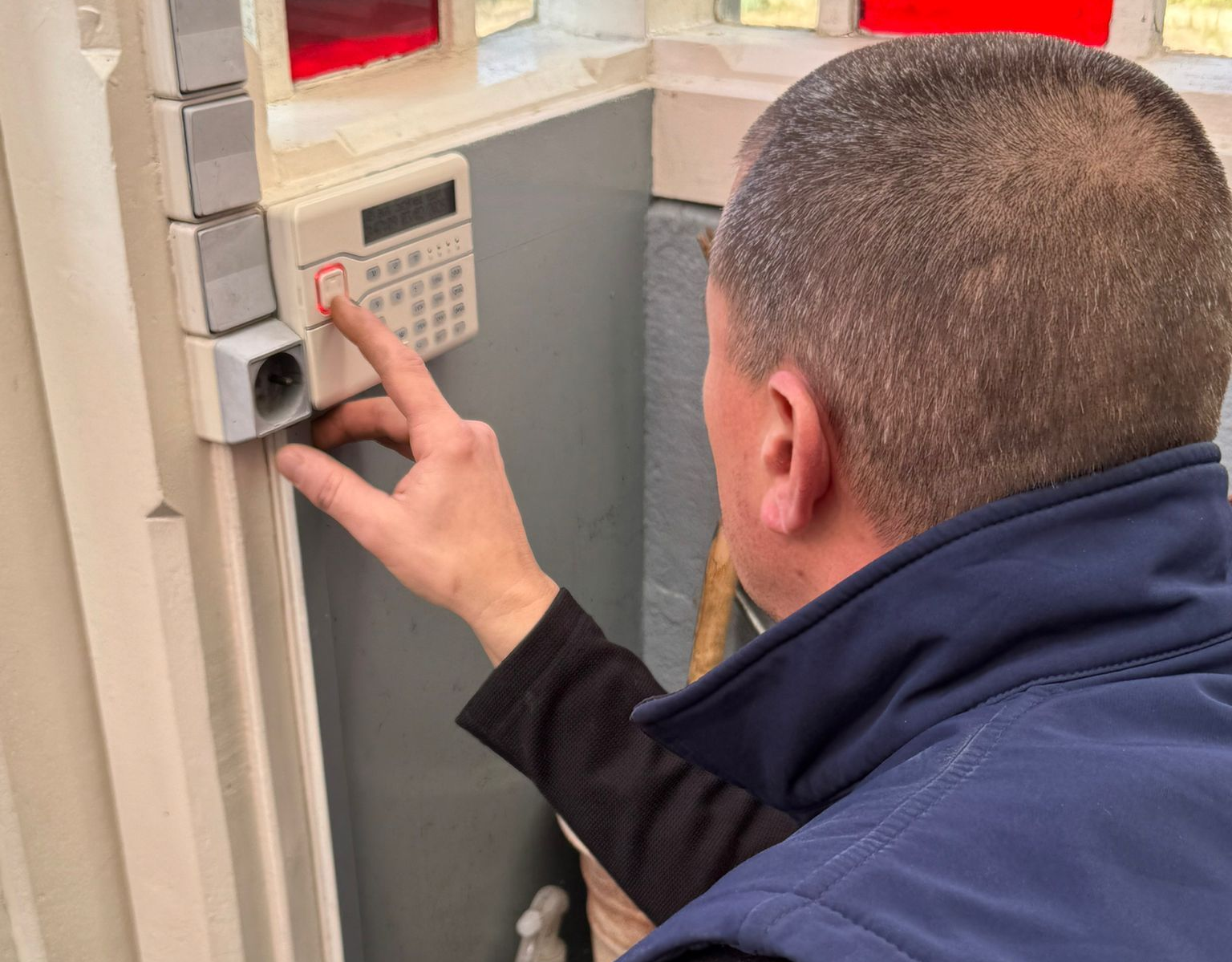 Capteur de fenêtre intelligent blanc avec bouton et voyant, fixé sur un cadre de fenêtre blanc.
