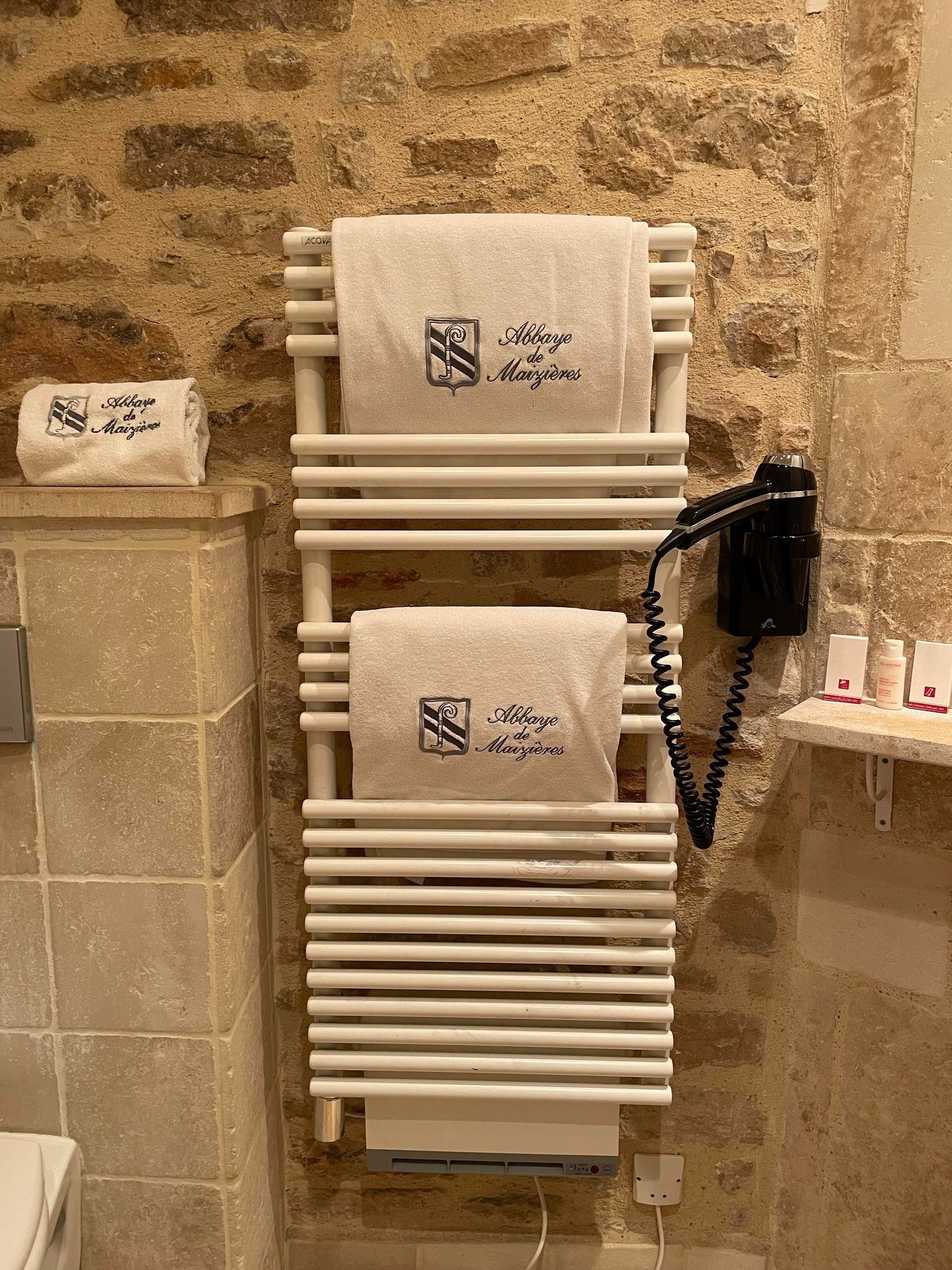 Un sèche serviette accroché sur un mur en pierre