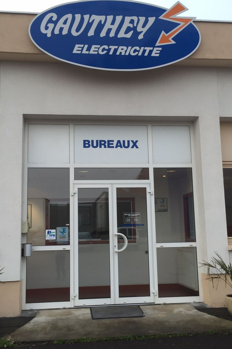 Entrée des bureaux de Gauthey Electricité avec enseigne bleue et blanche et portes vitrées.