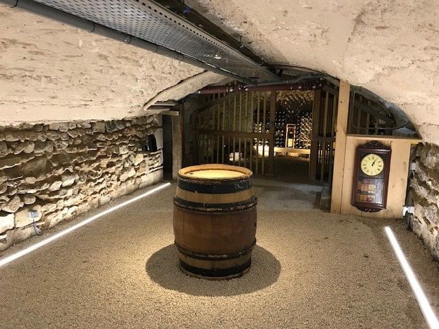 Pièce en rénovation, murs partiellement décapés, outils et débris éparpillés. Murs bleus, échelle jaune.