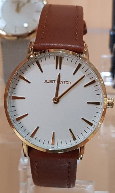 eine Uhr mit braunem Lederarmband und weißem Zifferblatt