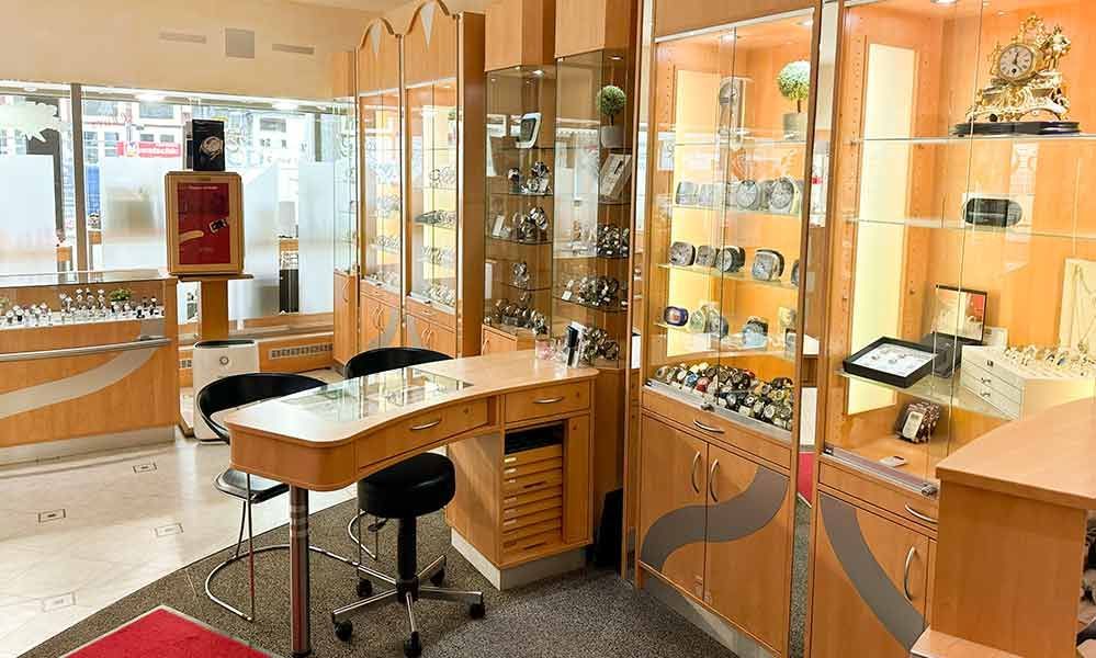 Ein Juweliergeschäft mit einem Tisch und Stühlen in der Mitte des Raumes.