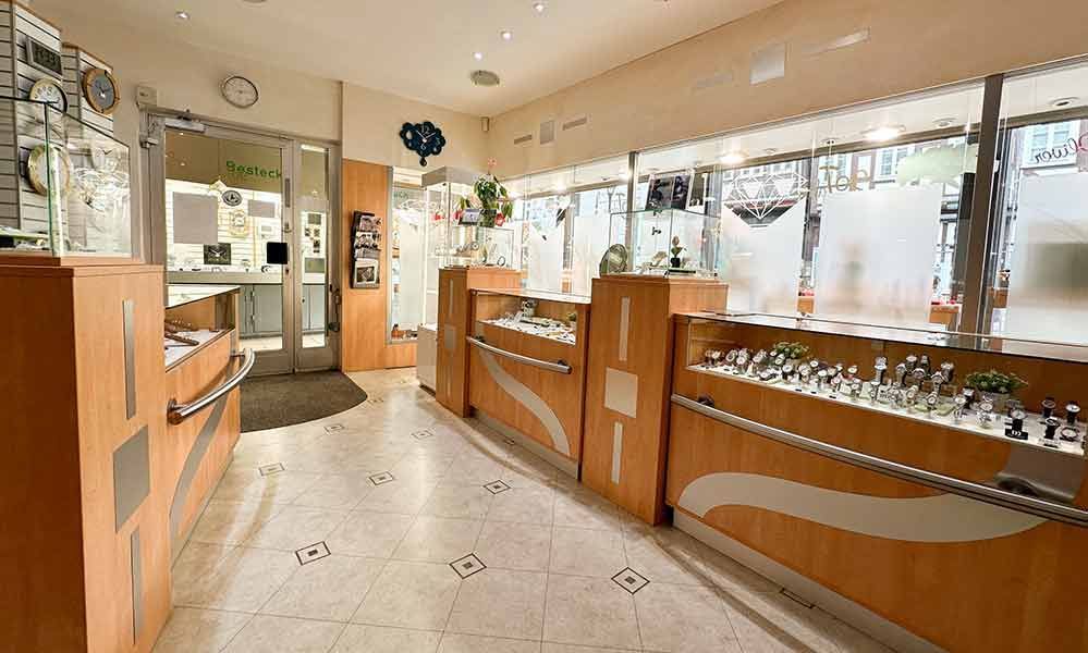 Ein langer Flur in einem Juweliergeschäft mit einer Uhr an der Wand.