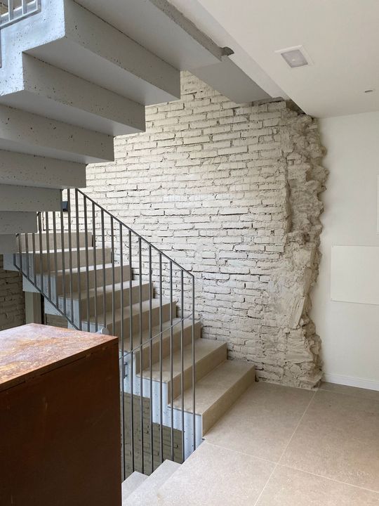 Una escala en un edifici amb un pilar i un banc.