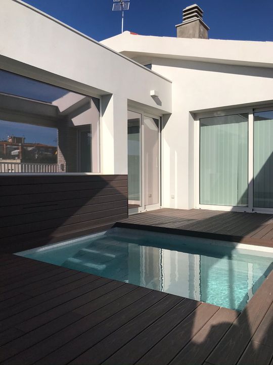 Un gran edifici blanc amb una piscina al davant