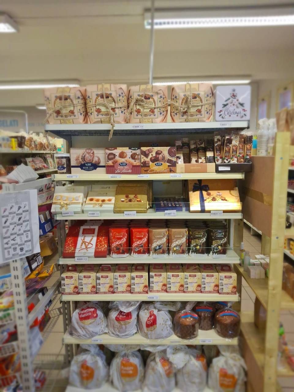 Scaffali pieni di vari prodotti alimentari confezionati, probabilmente in un supermercato.