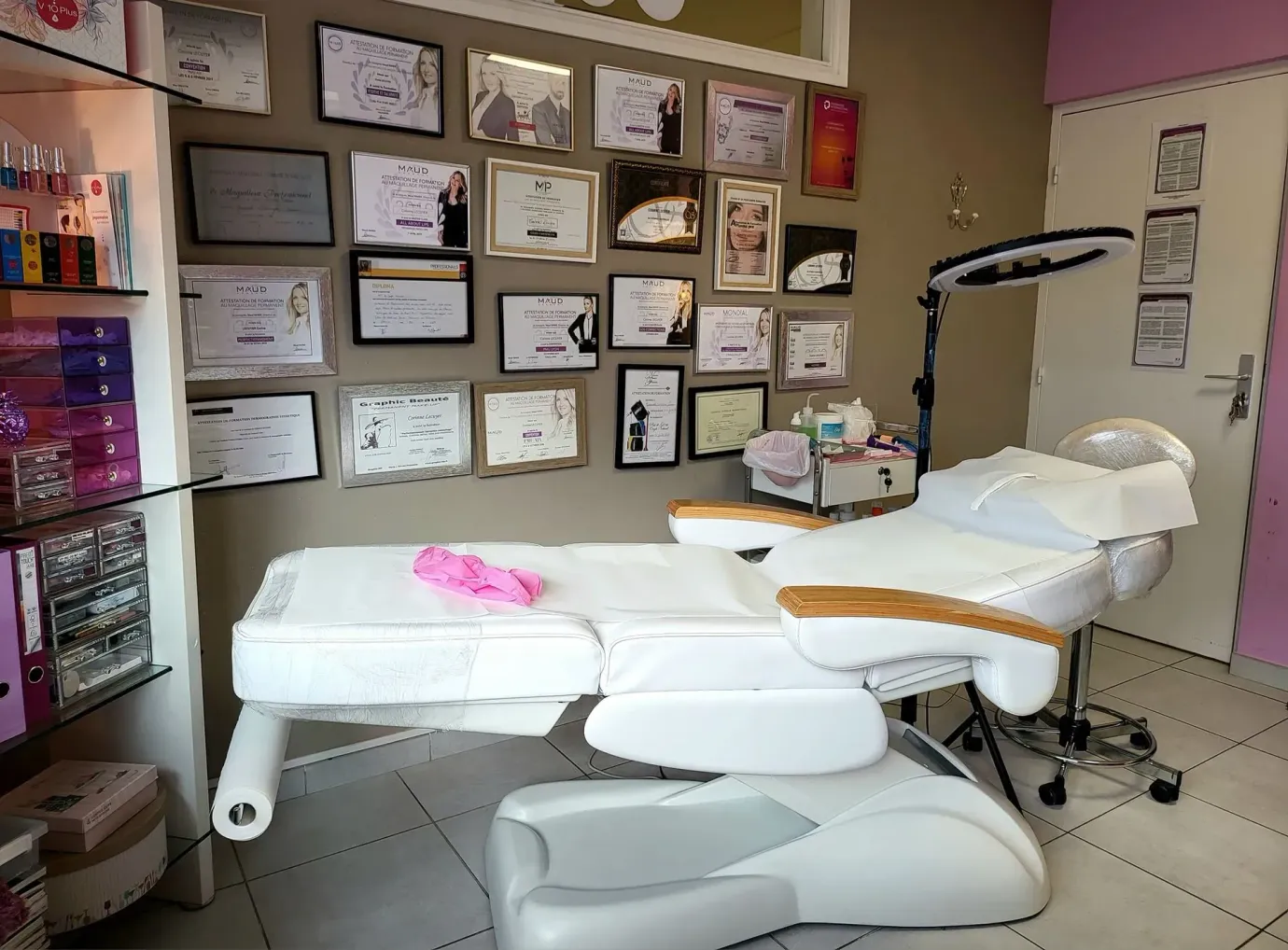Pièce avec des diplômes au mur et une table d'esthétique 