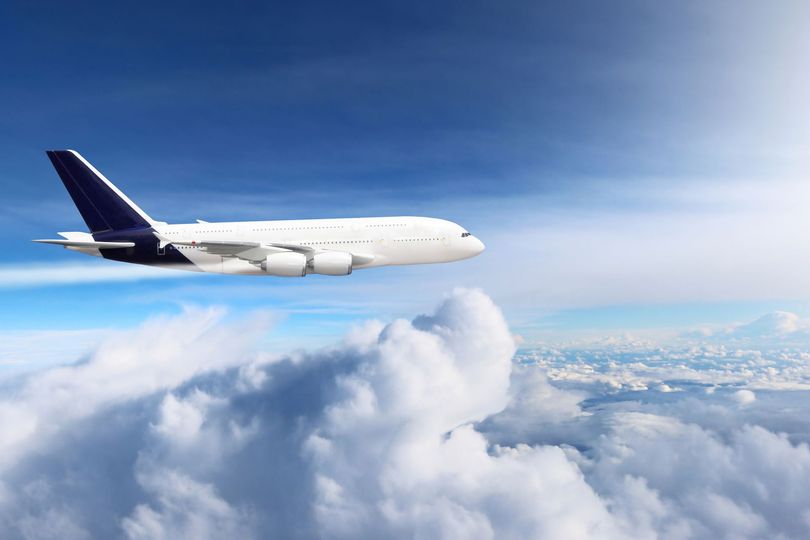 Avion de ligne volant au-dessus des nuages ​​dans un ciel bleu éclatant.