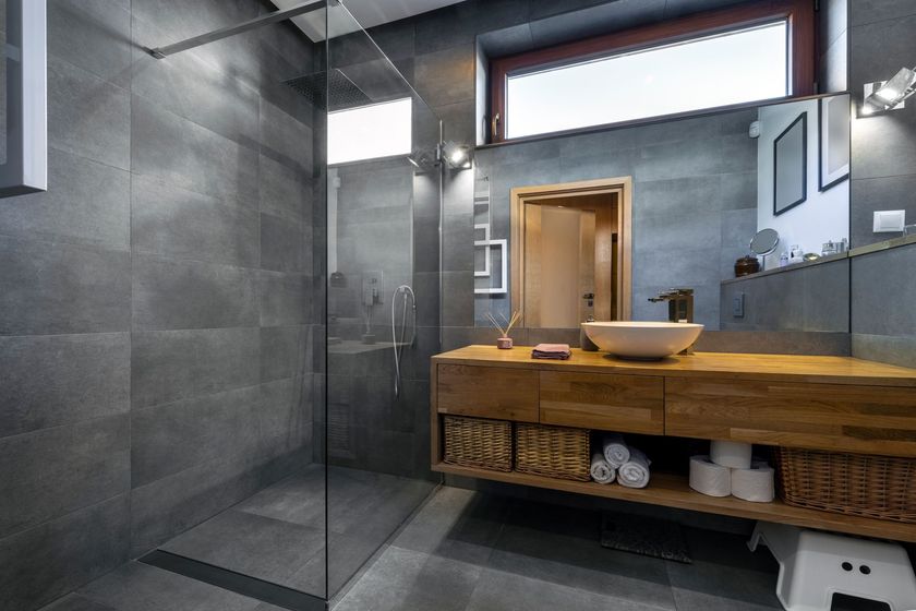 Salle de bains moderne avec carrelage, douche en verre, meuble-lavabo en bois et vasque.