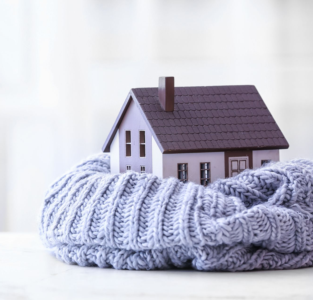 Petite maison miniature nichée dans un doux nid de couverture tricotée.