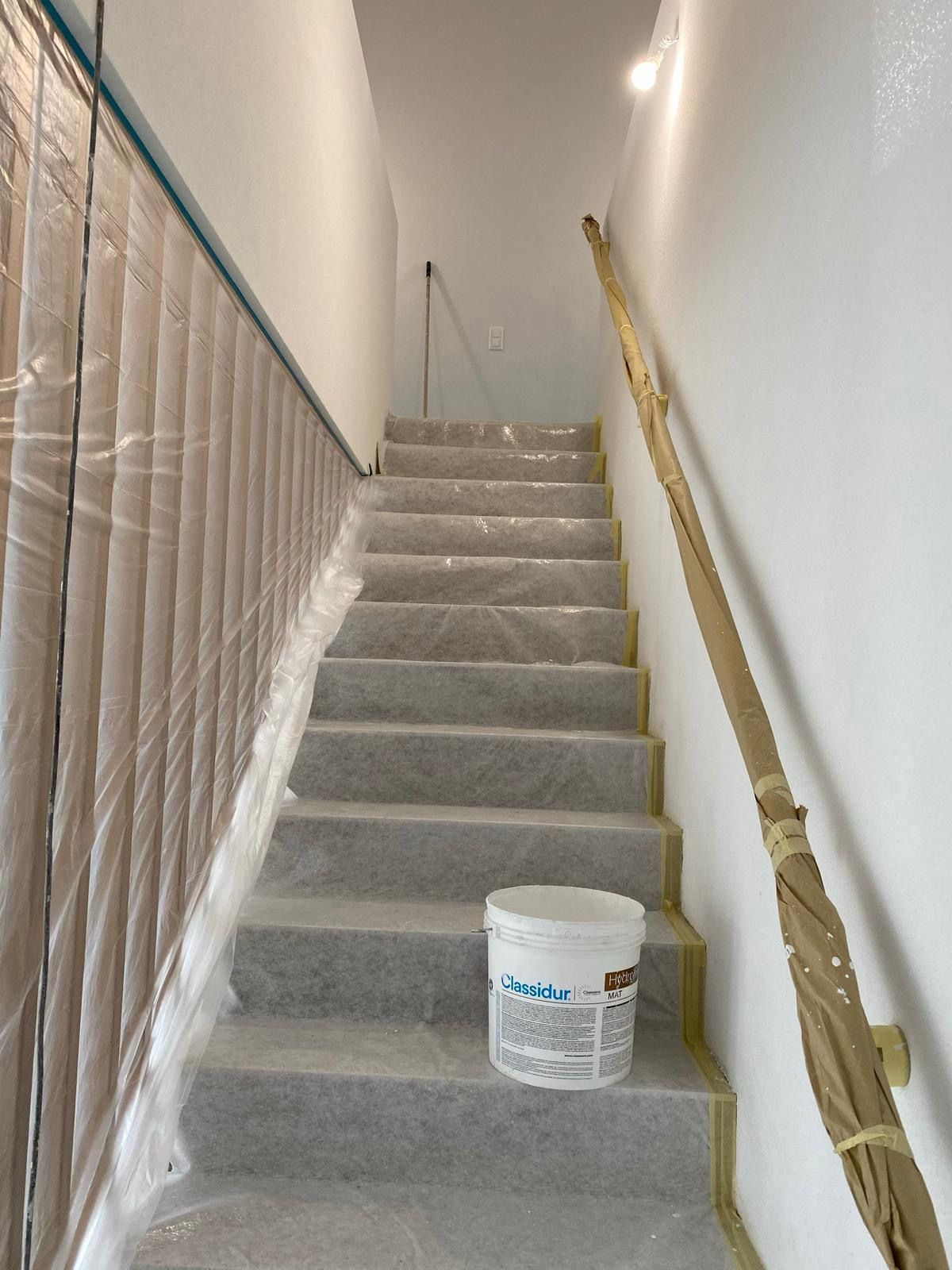 Un seau de peinture se trouve sur les marches d'un escalier
