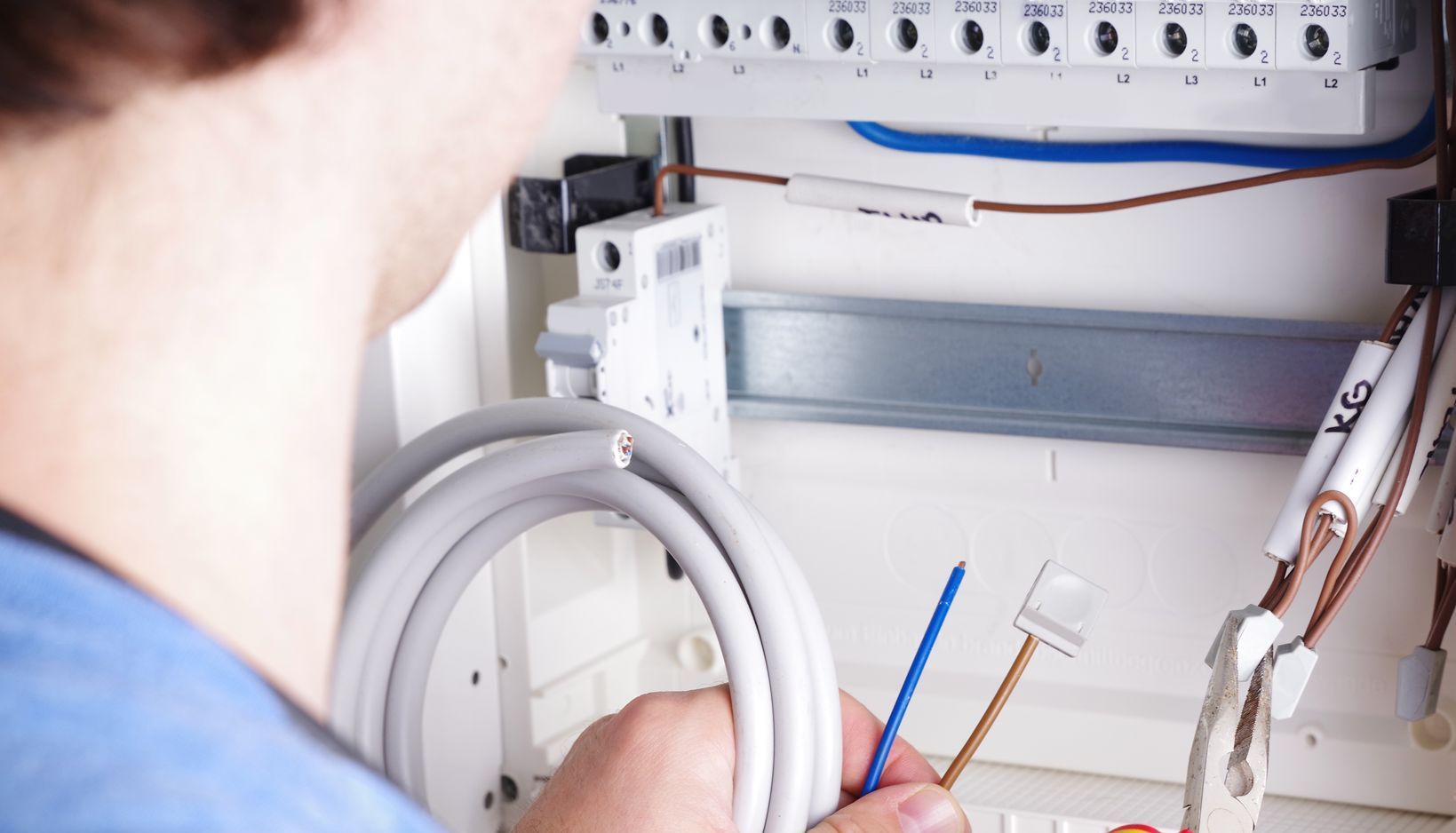 Mann vor Sicherungskasten