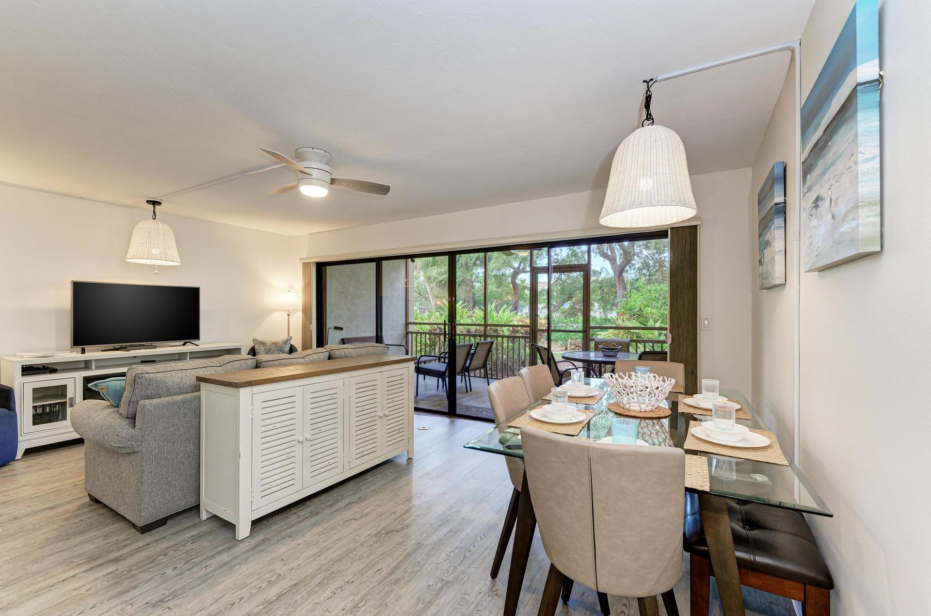 Dining area, queen sofa sleeper, fireplace under Smart TV, lanai with view of Marina