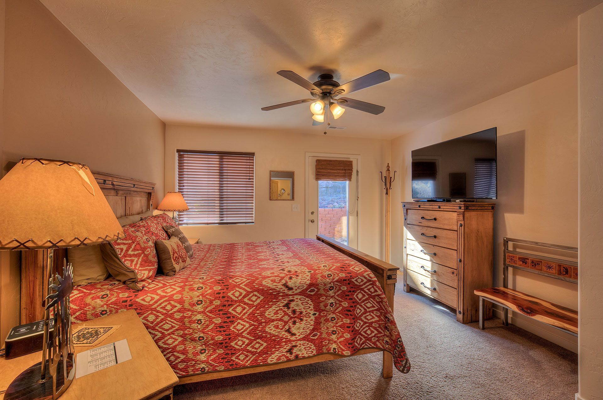 Moab, Utah Oleander Place vacation rental Bedroom with bed, dresser, window, and TV; southwestern style.