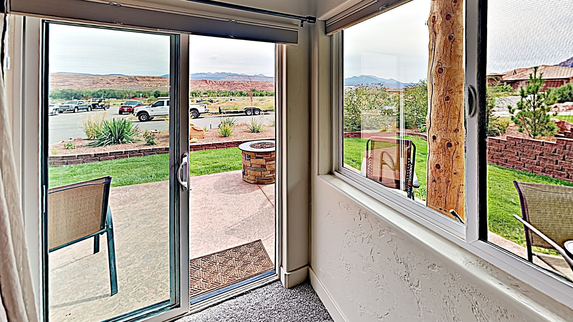 Village Place Moab vacation rental Indoor view: sliding glass door to patio with chairs, windows and outdoor scenery