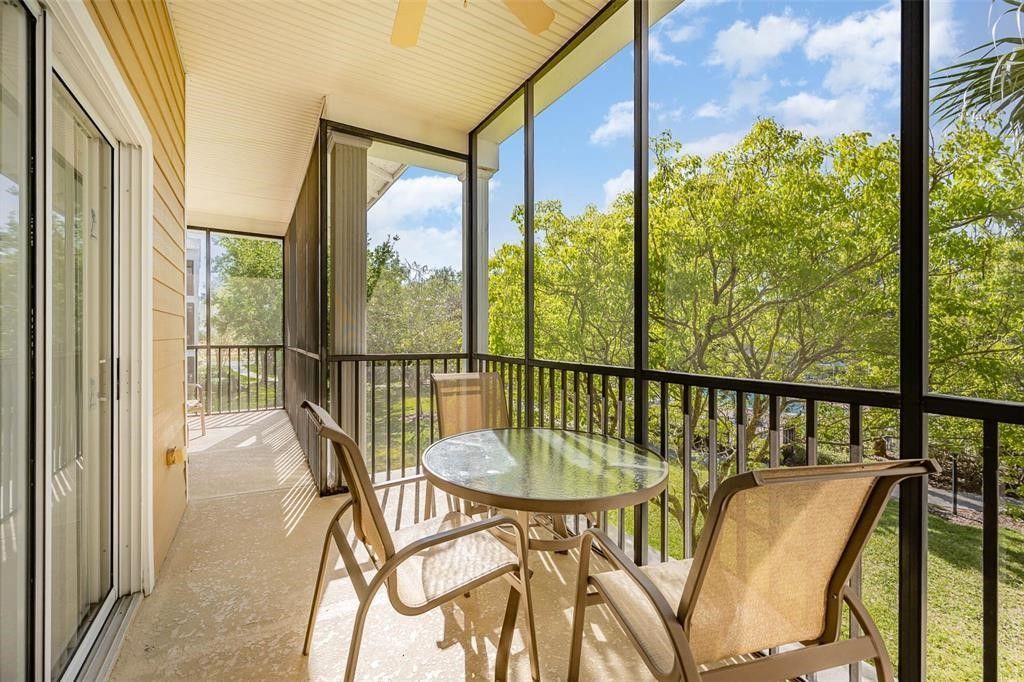 A screened in porch with a table and chairs and a ceiling fan at Orlando vacation rental 705 Rum Run at Bahama Bay