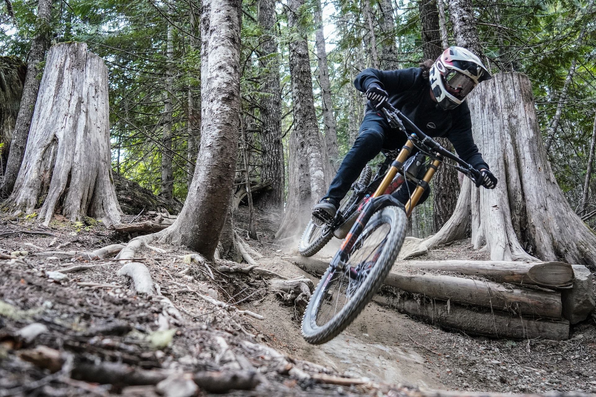 A person is riding a mountain bike down a trail in the woods.
