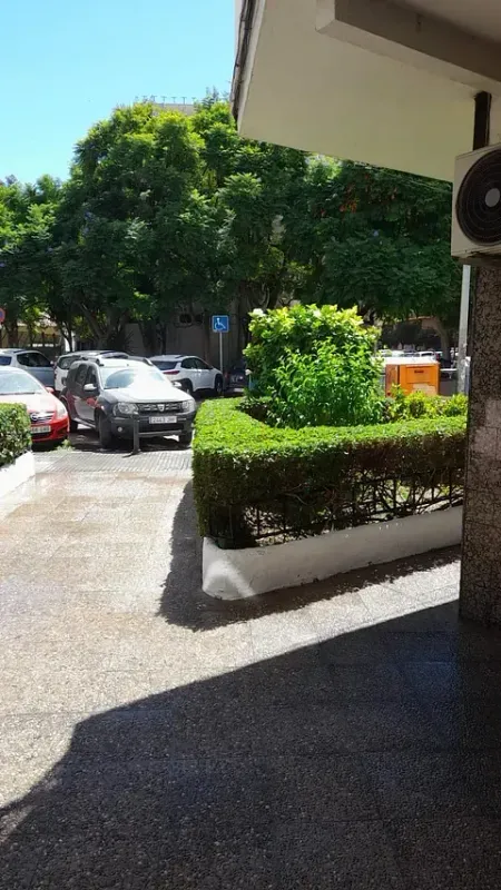 Un estacionamiento con autos estacionados frente a un edificio.