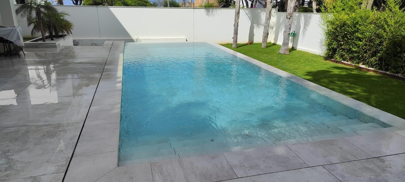 Una gran piscina en el patio trasero de una casa.