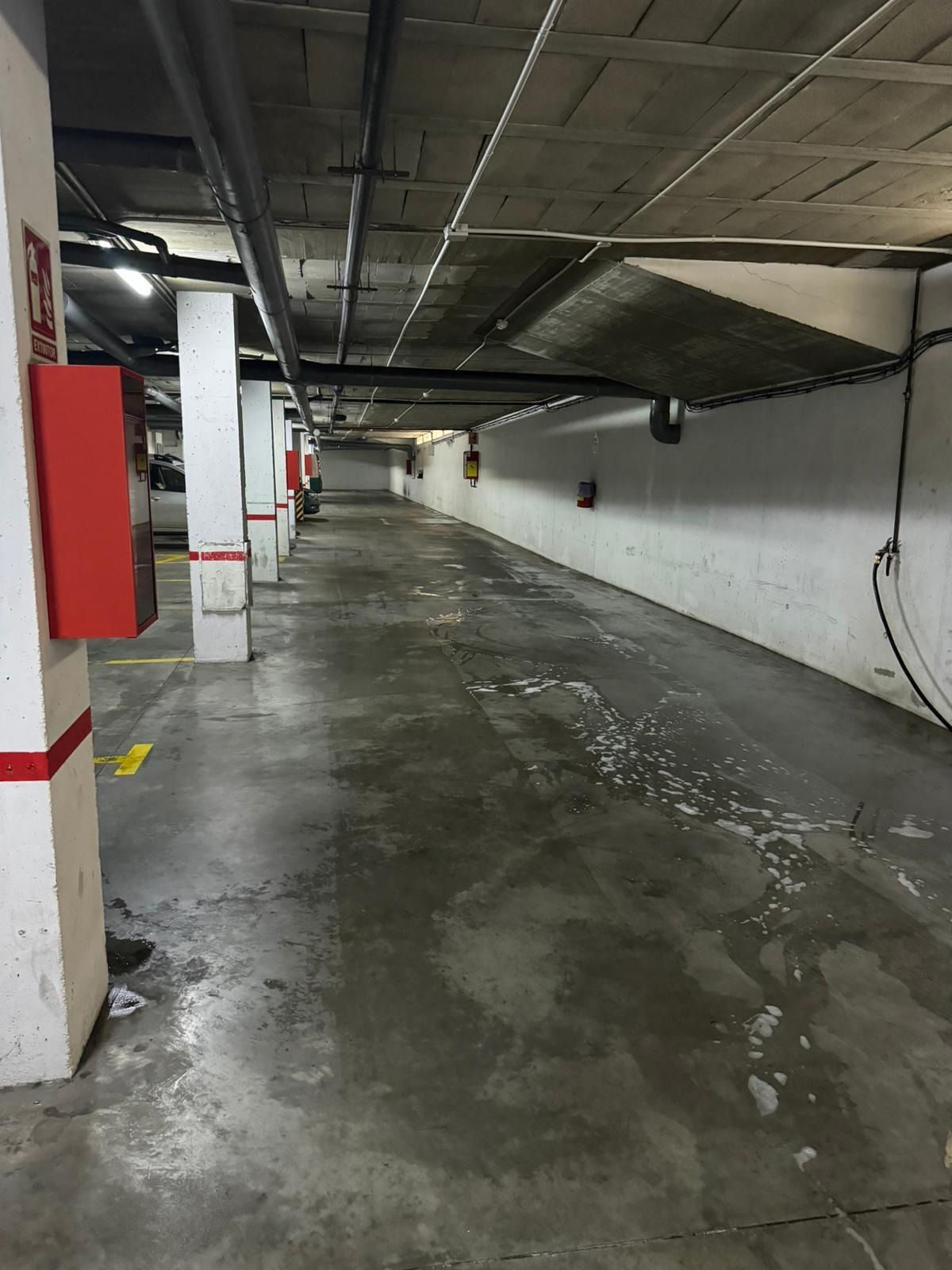 Un estacionamiento vacío con un extintor rojo