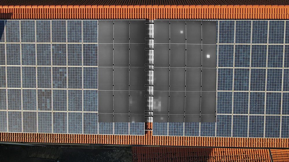 Eine Luftaufnahme einer Reihe von Solarmodulen auf dem Dach eines Gebäudes.