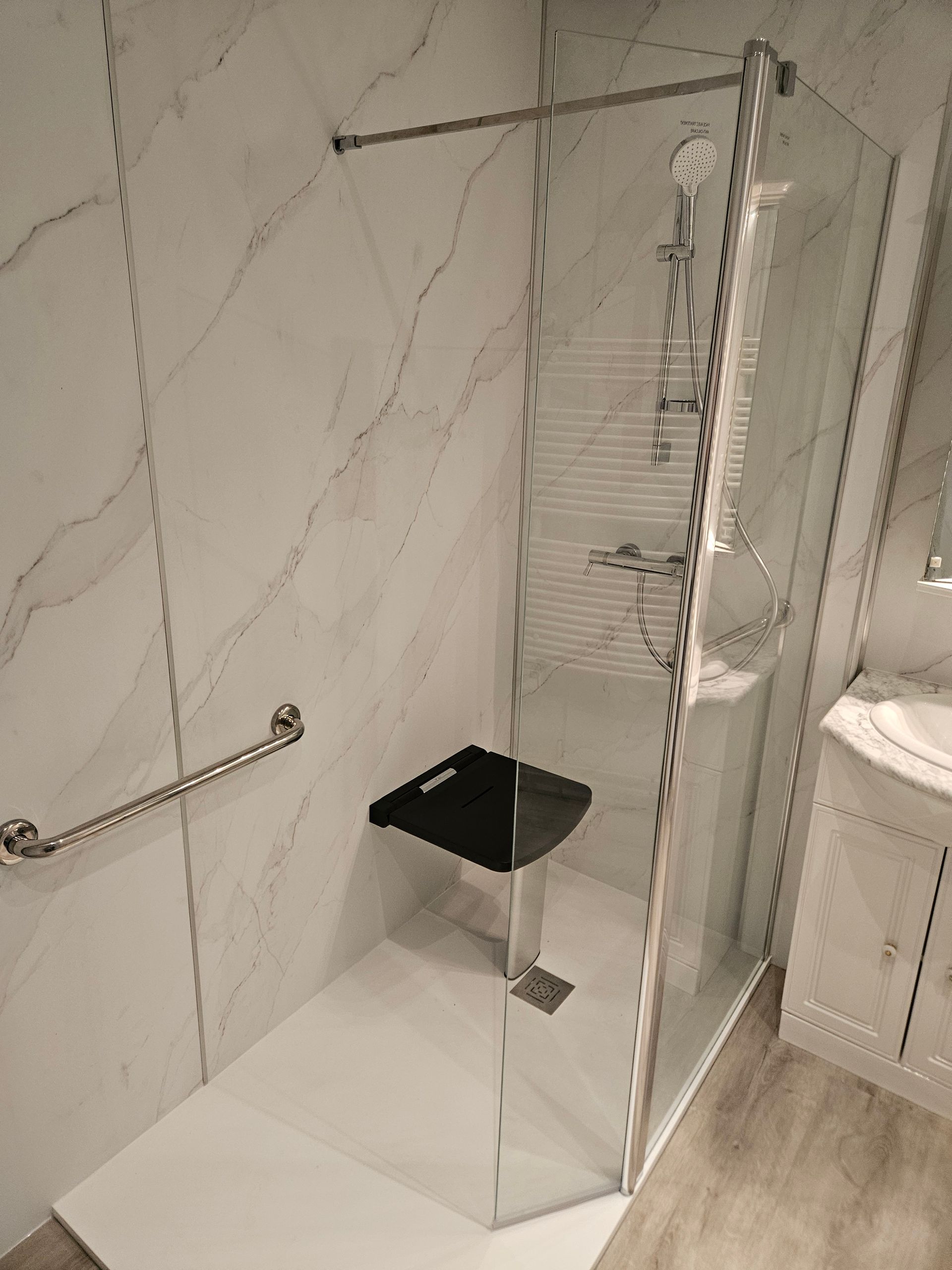 Douche PMR avec barre de maintien et siège de douche rabattable