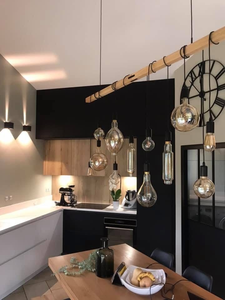 Un mur noir et des placards en bois clair créent un design moderne.