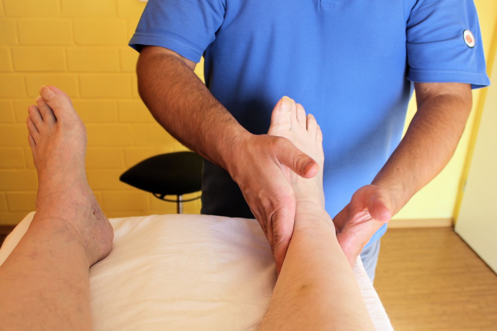 Eine Frau lässt ihr Knie von einem Physio untersuchen.