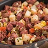Un primer plano de una sartén llena de carne y verduras.