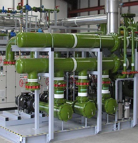 Sistema de tuberías industriales verdes sobre un marco de metal, con válvulas, conectado a bombas y controles.