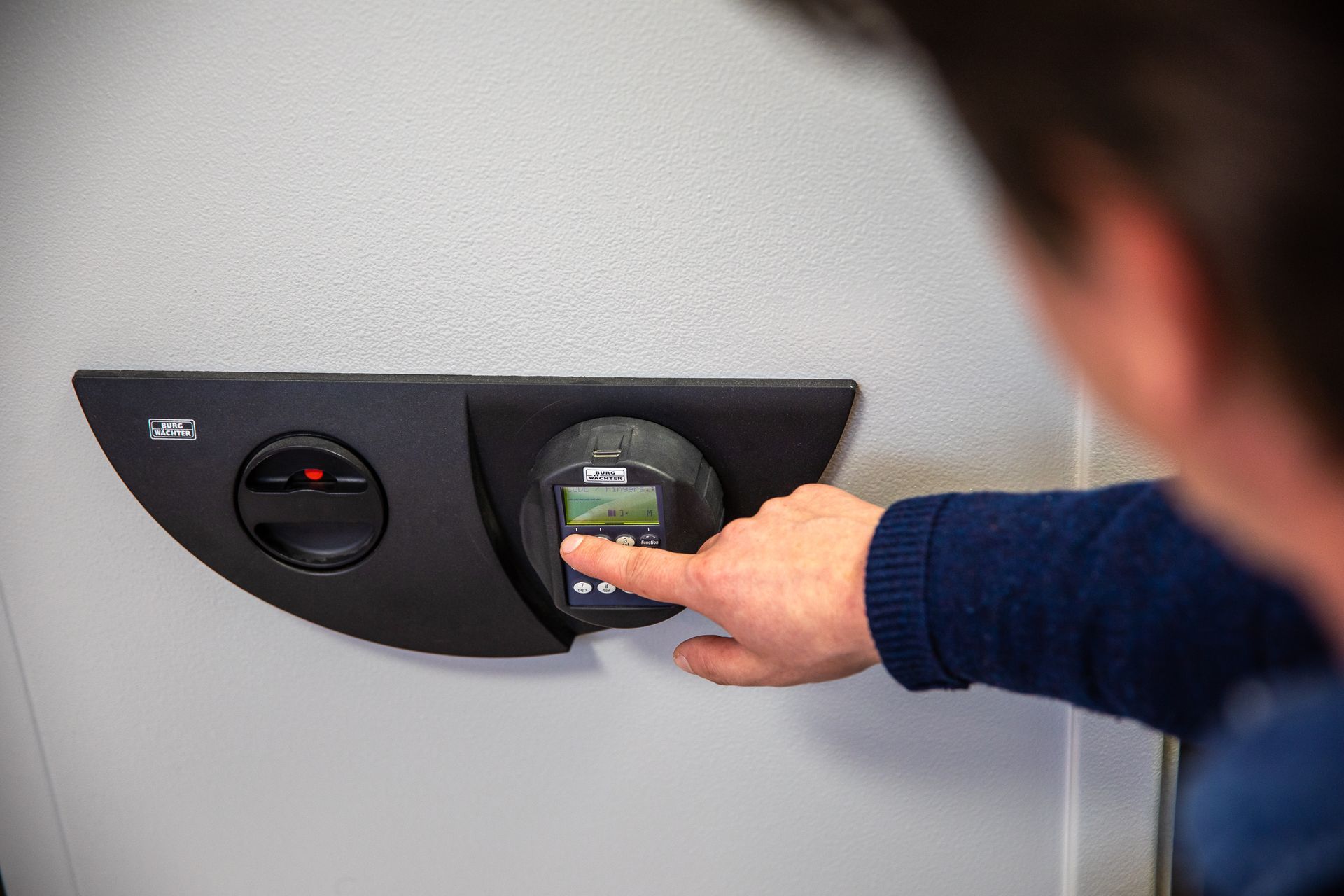 Un homme appuie sur le clavier d'un coffre-fort