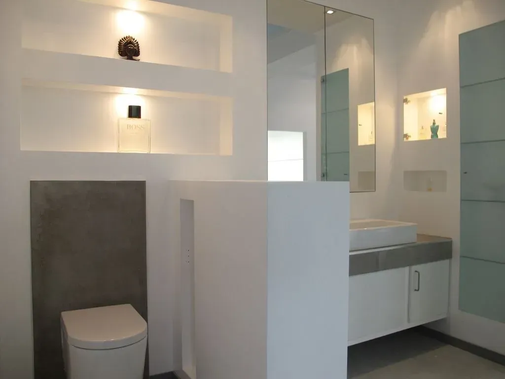 Ein Badezimmer mit Toilette, Waschbecken und Spiegel