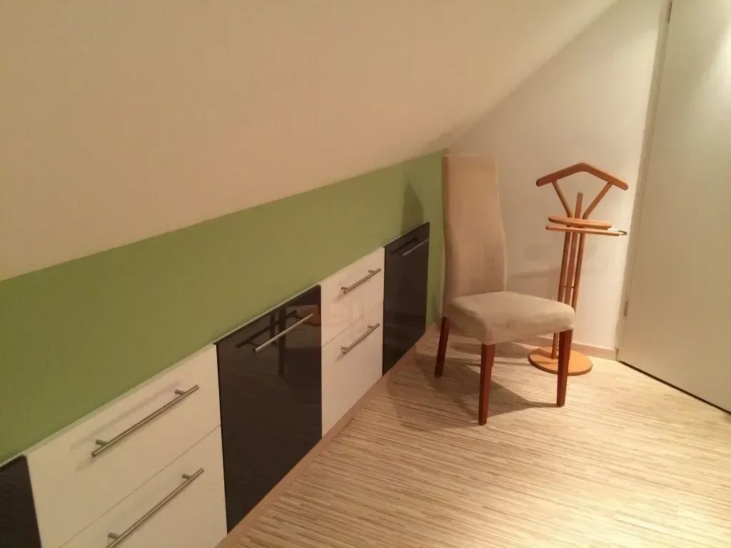 Ein Raum mit einem Stuhl und einem Kleiderbügel an der Wand