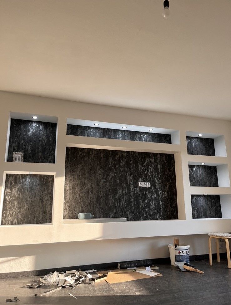 Ein leeres Wohnzimmer mit Kamin und Regalen im Aufbau