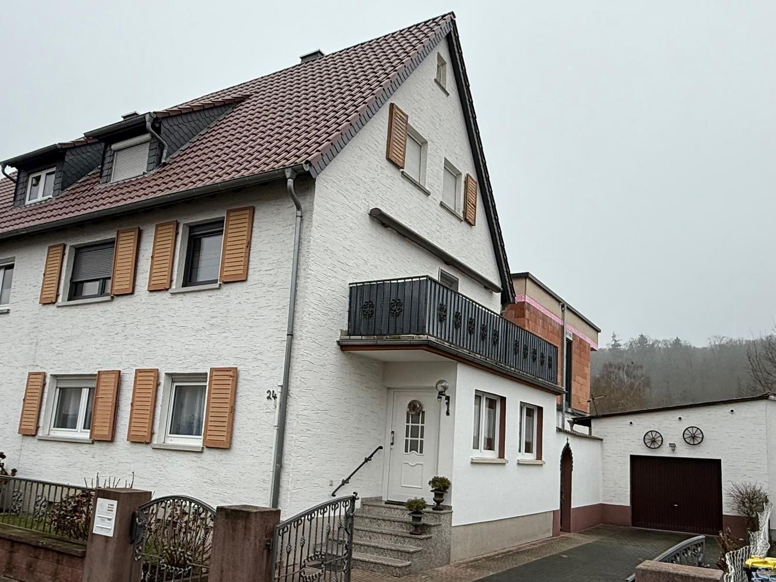 Eine Reihe farbenfroher Stadthäuser mit Solarpaneelen auf dem Dach unter blauem Himmel.