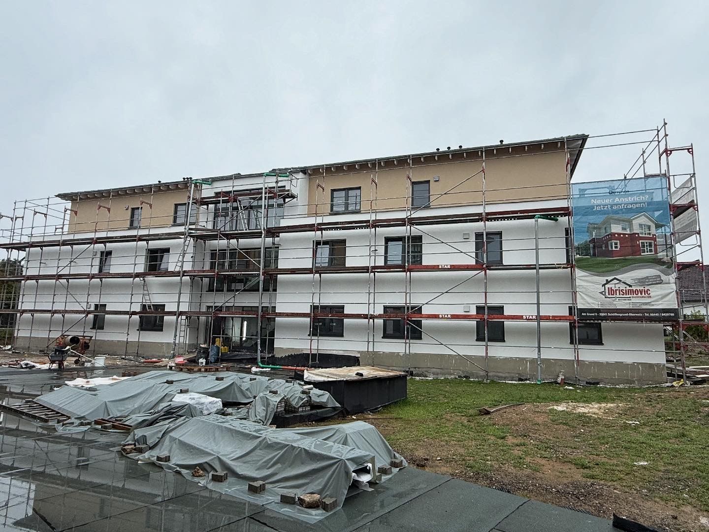 Eine Reihe bunter Stadthäuser mit Holzzäunen unter blauem Himmel.