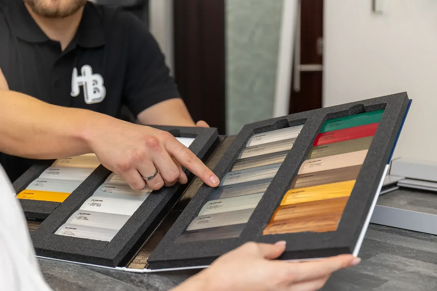 Ein Mann und eine Frau schauen sich ein Buch mit Holzmustern an.