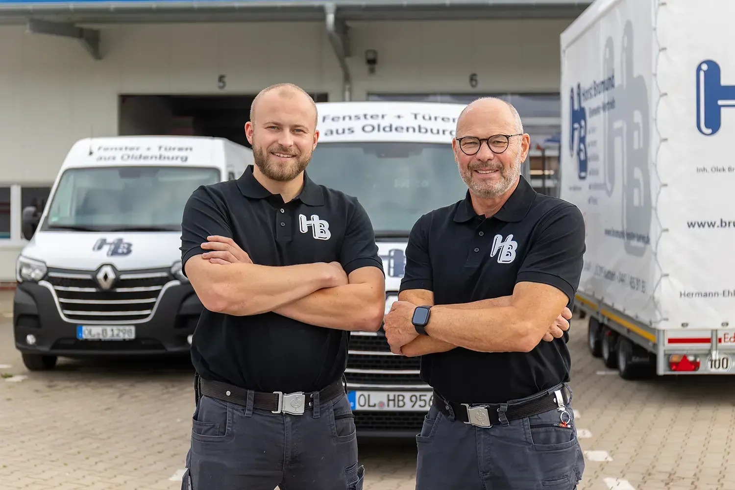 Zwei Männer stehen nebeneinander vor einem Lieferwagen.