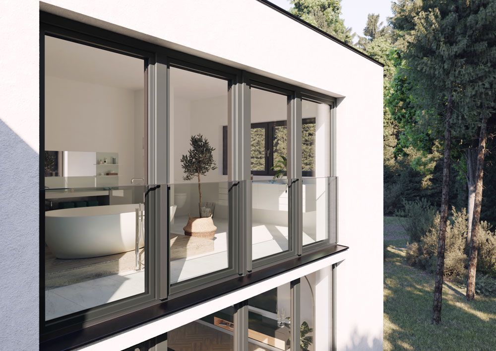 Ein weißes Haus mit vielen Fenstern und einem Balkon.