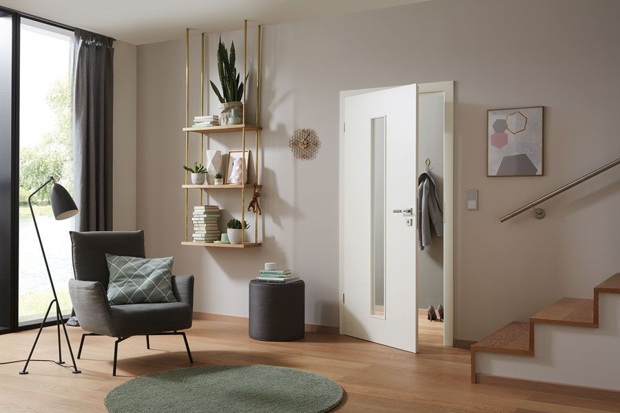 Ein Wohnzimmer mit Stuhl, Teppich, Lampe und Treppe.