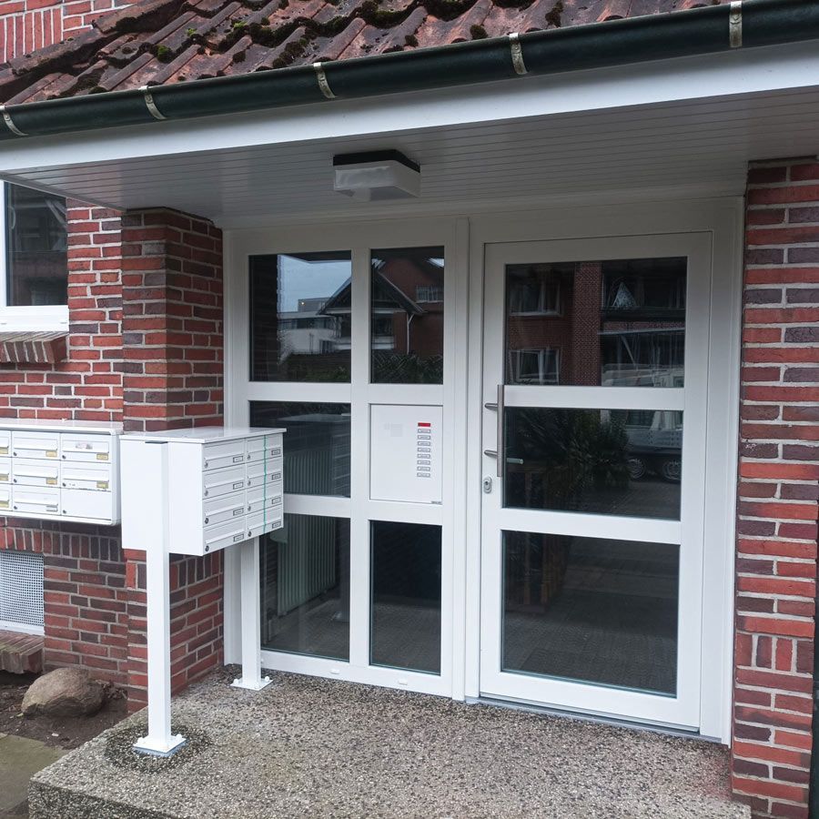 Ein Backsteingebäude mit einer weißen Tür und Briefkästen