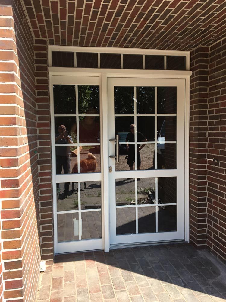 Eine weiße Tür mit einer Ziegelwand dahinter