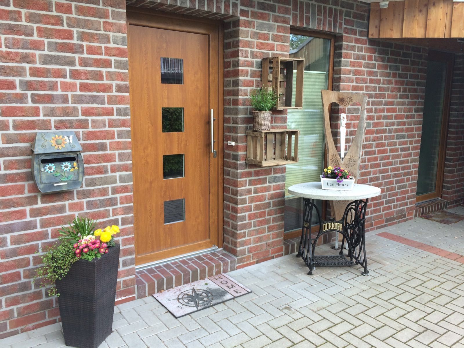 Ein Backsteingebäude mit einer Holztür und einem Tisch davor.