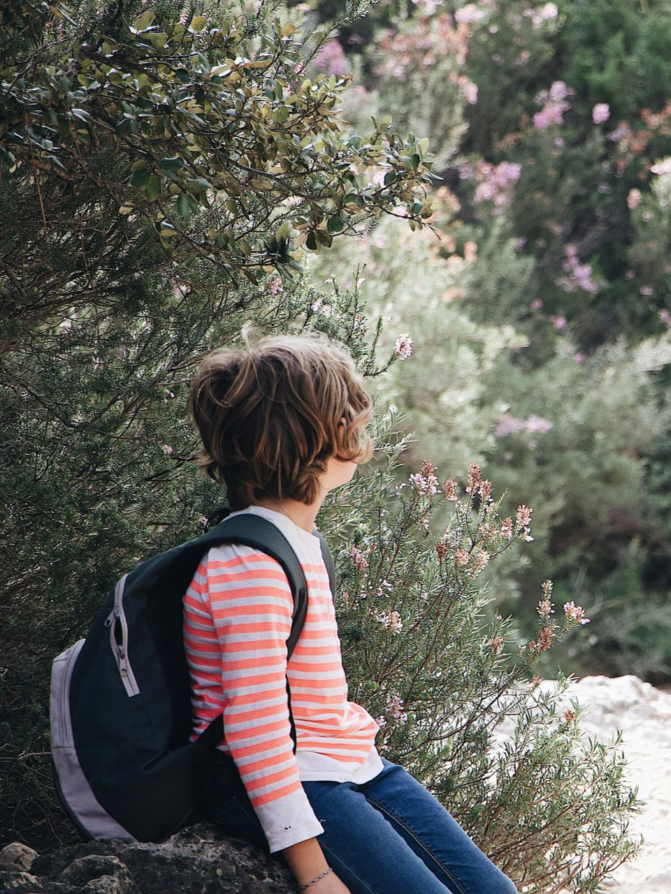 Une personne pratiquant un acrobatie aérienne sur tissu rouge, sous le regard de spectateurs prenant des photos dans une salle de sport.