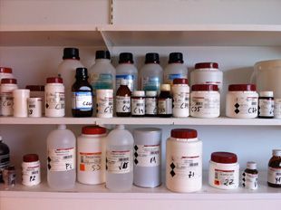 Un estante lleno de muchas botellas y frascos de productos químicos.