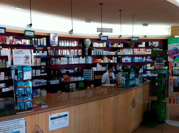 Un hombre se sienta en el mostrador de una farmacia.