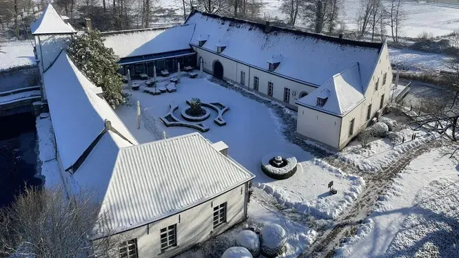 An aerial view of a house covered in snow