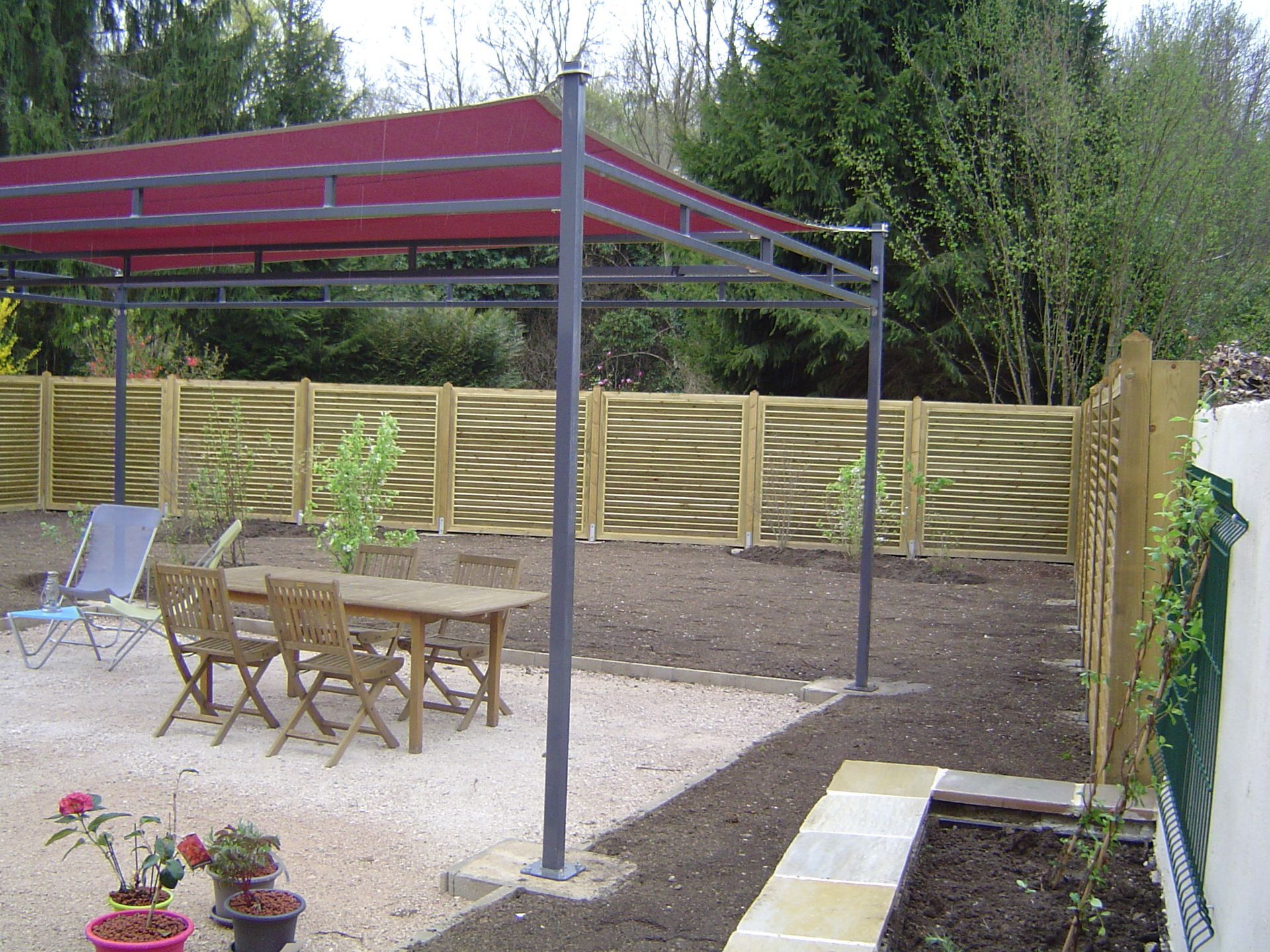 Une pergola avec un salon de jardin